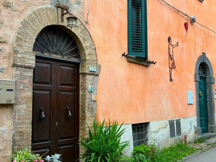 إحدى أعمال بانكسي على جدار شارع مدينة آسيزي. أبريل 2025 - annesitaly.com