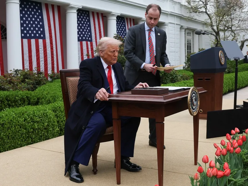 الرئيس الأميركي دونالد ترمب في حديقة البيت الأبيض يوقع أوامر تنفيذية بفرض رسوم جمركية على كافة الشركاء التجاريين لبلاده. 2 أبريل 2025 - REUTERS