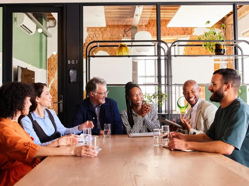 مجموعة من الأشخاص يضحكون خلال أحد اجتماعات العمل - Getty Images