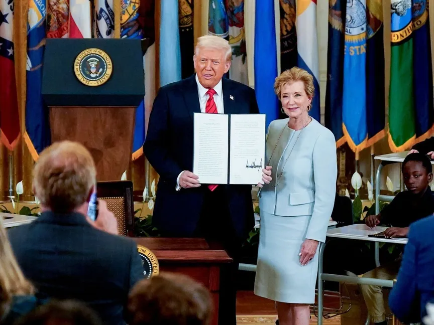 الرئيس الأميركي دونالد ترمب إلى جانب وزيرة التعليم ماكماهون خلال توقيع أمر تنفيذي في البيت الأبيض. 20 مارس 2025 - Bloomberg