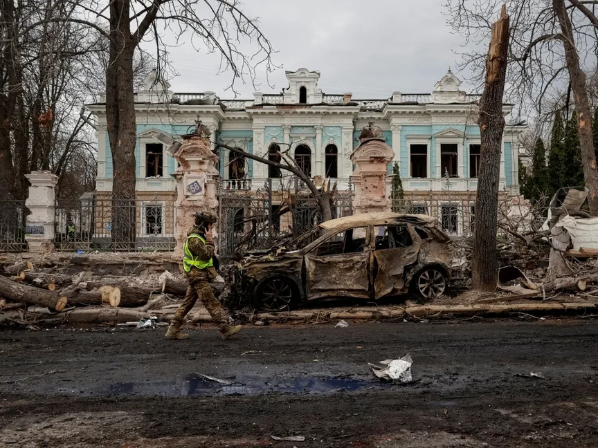 جندي أوكراني يسير في موقع ضربة صاروخية في مدينة سومي، شمال أوكرانيا، 13 أبريل 2025 - Reuters