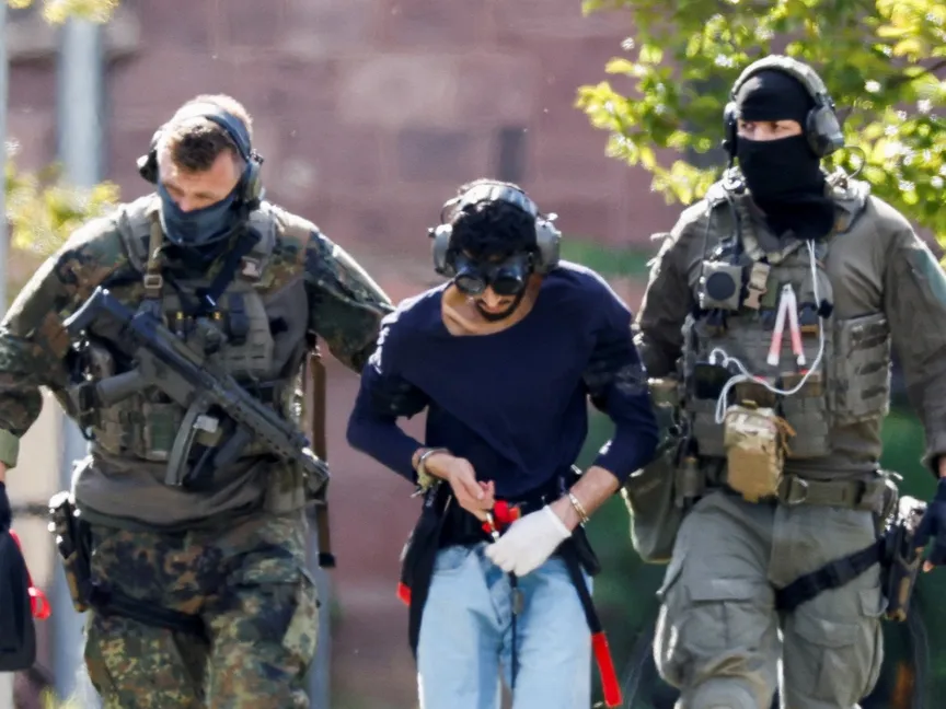 رجال شرطة ألمان يرافقون شاباً سوري الجنسية مشتبهاً به في عملية طعن راح ضحيتها عدد من الأشخاص بولاية شمال الراين وستفاليا- 25 أغسطس 2024 - Reuters