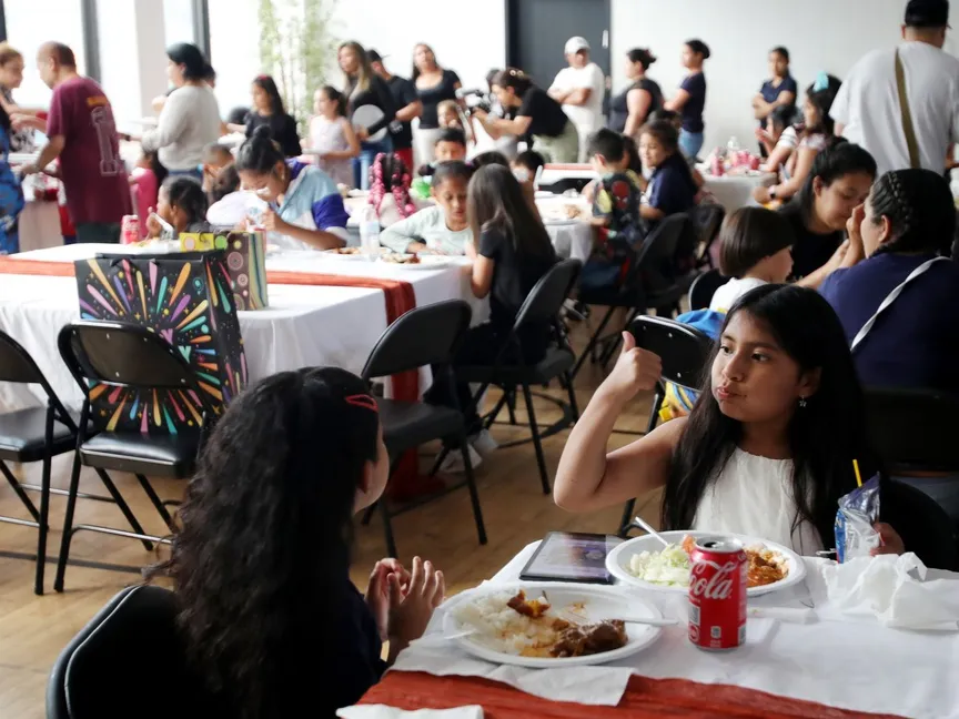 أطفال وعائلات مهاجرين يتناولون الغذاء في مركز لإيواء المهاجرين في مركز روميمو، نيويورك. 27 يونيو 2023 - AFP