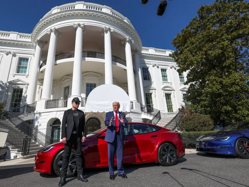 الرئيس الأميركي دونالد ترمب والرئيس التنفيذي لشركة تسلا إيلون ماسك يقفان أمام سيارة تسلا في البيت الأبيض. 11 مارس 2025 - REUTERS