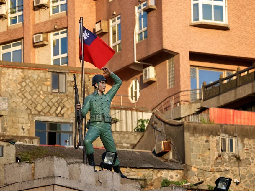 علم تايوان يرفرف وراء تمثال لجندي في تايبيه - 15 أغسطس 2022 - REUTERS