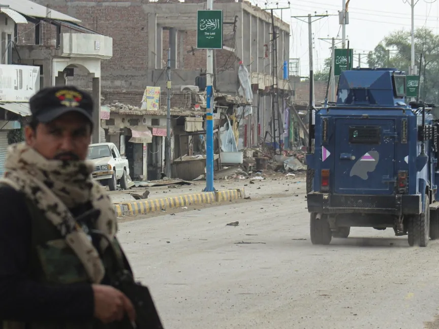 شرطي باكستاني يقف في شارع تظهر في خلفيته متاجر متضررة عقب هجوم مسلح على مقر قوات حرس الحدود في بانو بإقليم خيبر بختونخوا في باكستان. 2 سبتمبر 2025 - reuters