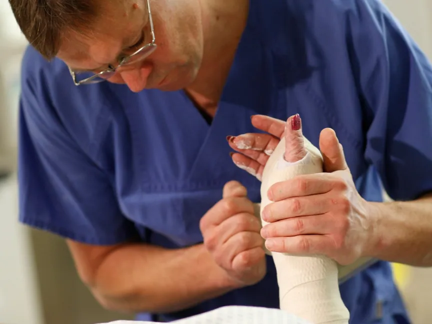 ممرض في برلين يساعد مريضته على وضع جبيرة اليد بعد كسر في معصميها. برلين في 6 يناير 2011 - reuters