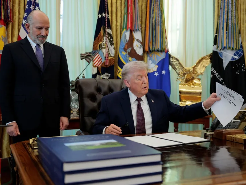 الرئيس الأميركي دونالد ترمب يتحدث بجوار وزير التجارة هوارد لوتنيك خلال مراسم توقيع أمر تنفيذي بشأن الاقتراع عبر البريد في المكتب البيضاوي بالبيت الأبيض. 31 مارس 2026 - reuters