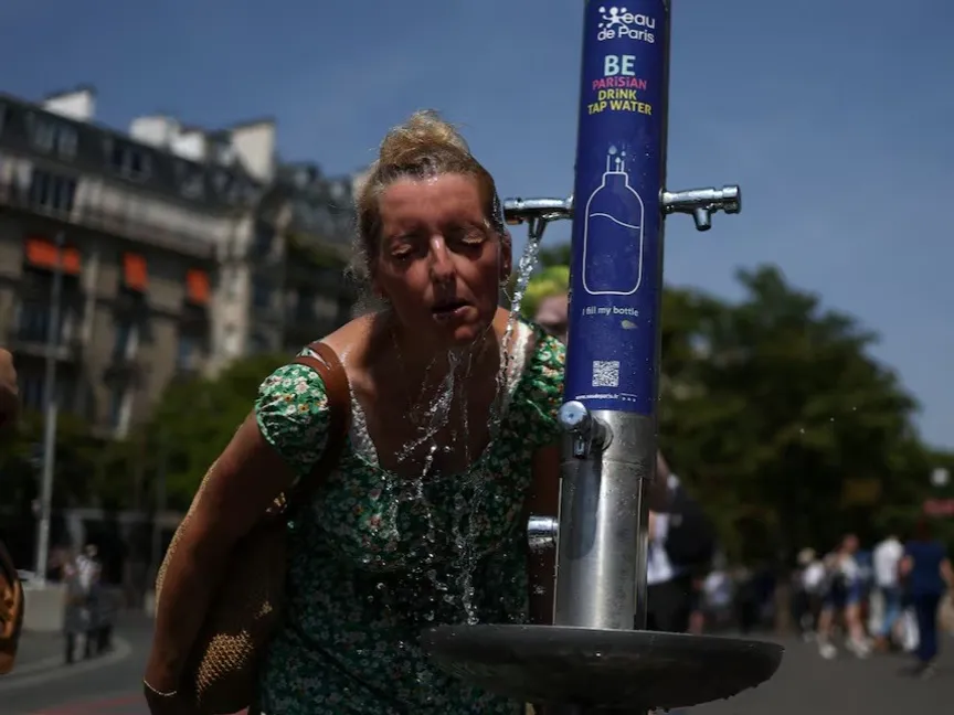 امرأة تغمر وجهها بالماء من صنبور عام قرب ساحة تروكاديرو، باريس، فرنسا. 27 يونيو 2026 - Reuters