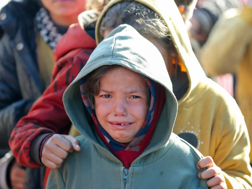 طفل فلسطيني يبكي خلال انتظاره في طابور لتلقي الطعام في خان يونس جنوبي قطاع غزة. 2 يناير 2025 - Reuters