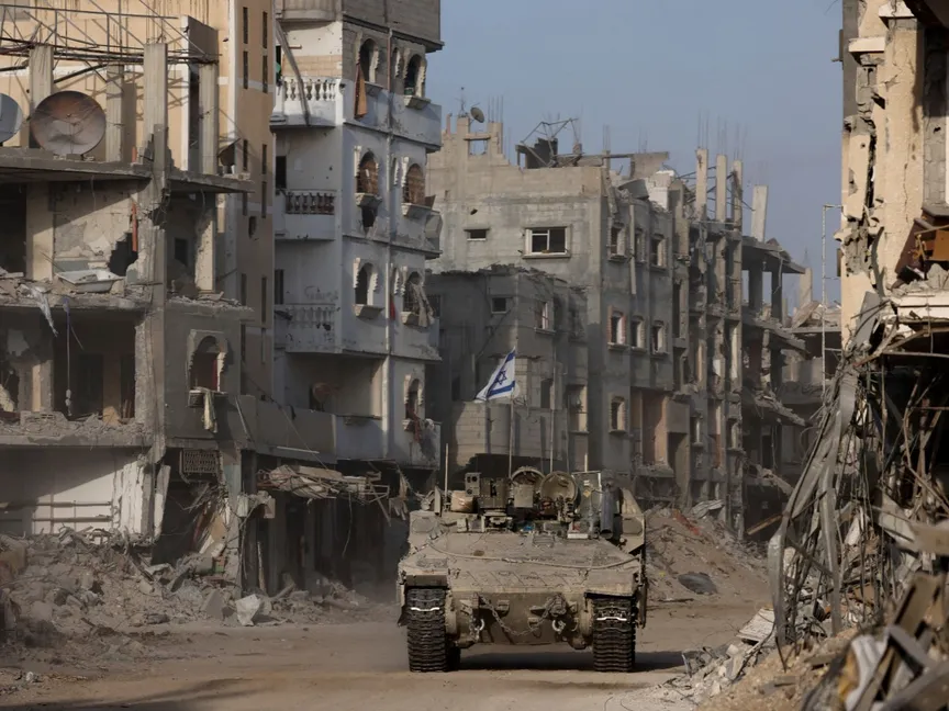 مدرعة تابعة للجيش الإسرائيلي تتحرك في قطاع غزة بينما تظهر في الخلفية مبانٍ متضررة وسط استمرار الحرب على القطاع. 13 سبتمبر 2024 - Reuters