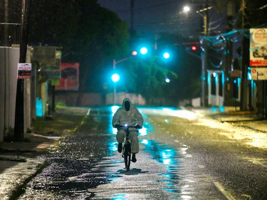 رجل يرتدي بدلة واقية يركب دراجته في أحد الشوارع مع اقتراب إعصار ميليسا في كينجستون. جامايكا في 27 أكتوبر 2025 - reuters