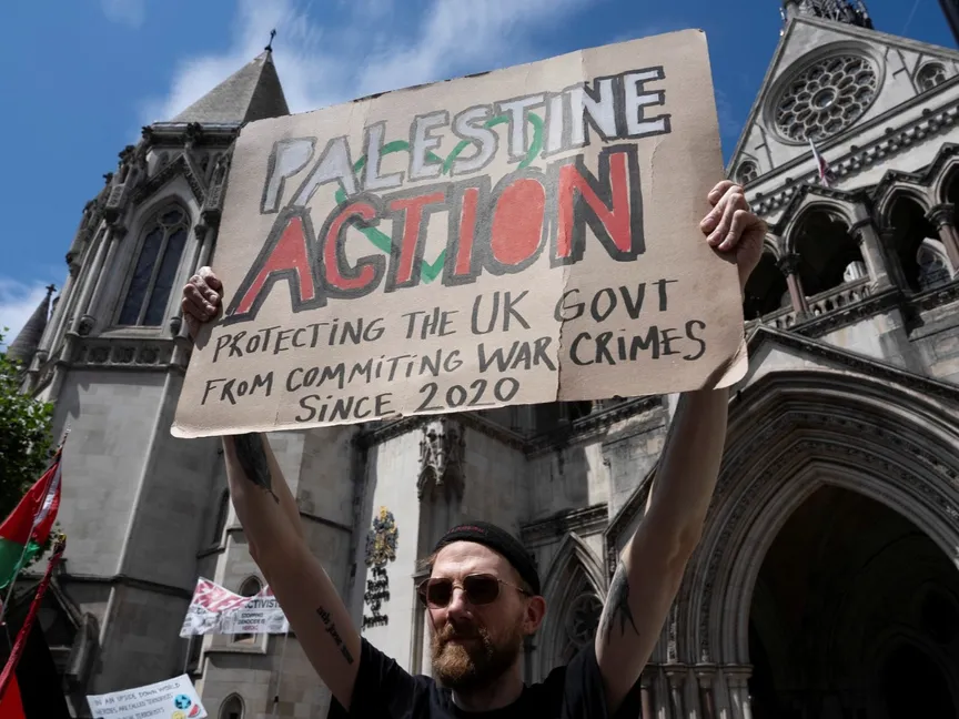 مؤيد لحركة "فلسطين أكشن" يحمل لافتة أمام المحكمة العليا في العاصمة البريطانية لندن. 4 يوليو 2025 - REUTERS