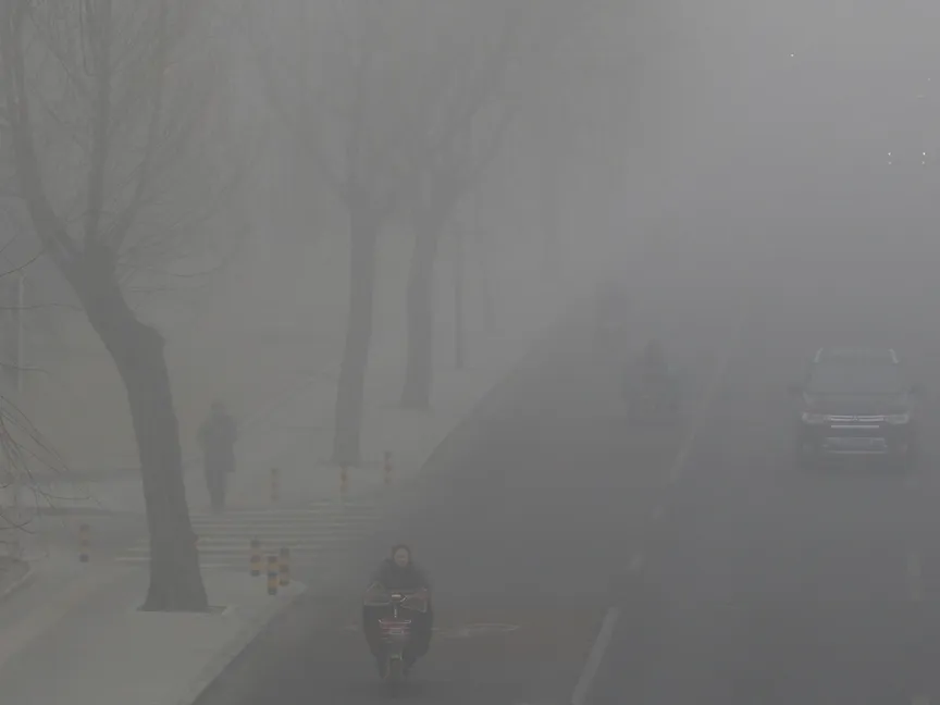 أشخاص يقودون سياراتهم وسط دخان ناتج عن التلوث في العاصمة الصينية بكين. 14 فبراير 2017 - REUTERS