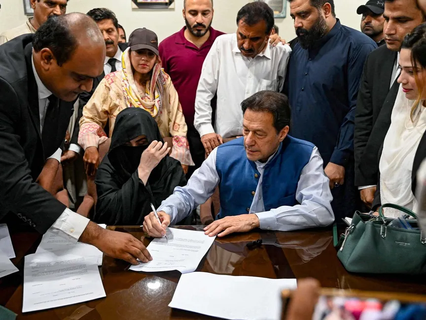 رئيس وزراء باكستان السابق عمران خان مع زوجته بشرى بيبي يوقعان سندات ضمان للكفالة في قضايا مختلفة بمكتب المسجل بالمحكمة العليا في لاهور. 17 يوليو 2023 - AFP