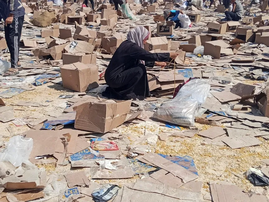 فلسطينيية تحاول جمع ما تبقى من إمدادات الإغاثة في رفح، جنوب قطاع غزة. 5 يونيو 2025 - Reuters