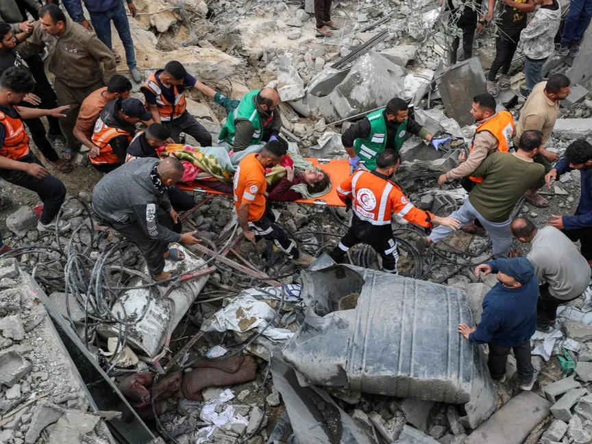 فلسطينيون يحملون مصابة تم إخراجها من تحت أنقاض دمرته غارة إسرائيلية في جباليا شمال قطاع غزة. 13 أبريل 2025 - REUTERS