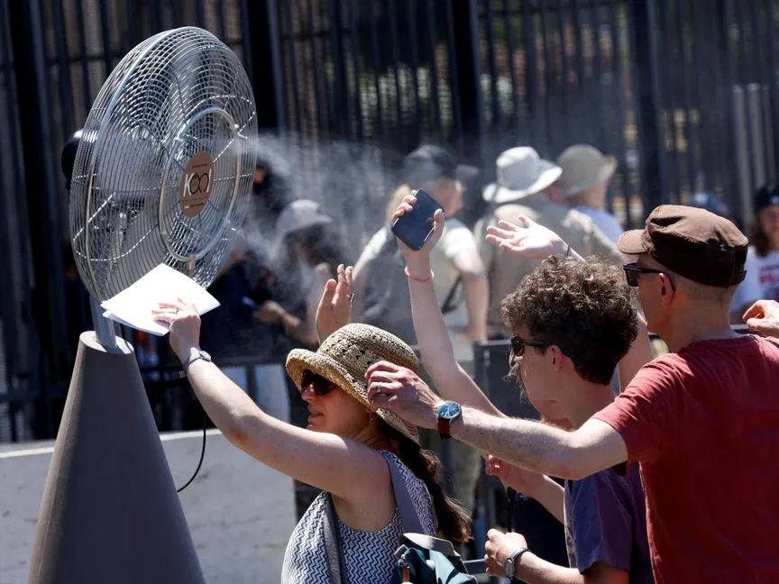 سياح يقفون أمام مروحة تبريد تم تركيبها خارج الكولوسيوم خلال موجة الحر في روما. 30 يونيو 2025 - Reuters