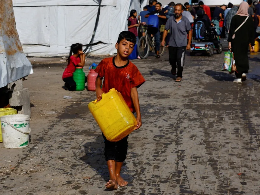 طفل فلسطيني نازح يحمل حاوية مياه في وسط قطاع غزة. 4 أكتوبر 2025 - Reuters