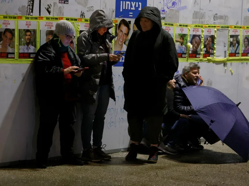 أشخاص يحتمون بجدار في القدس مع انطلاق صفارات إنذار تشير إلى هجوم صاروخي من اليمن على إسرائيل. 20 مارس 2025 - REUTERS