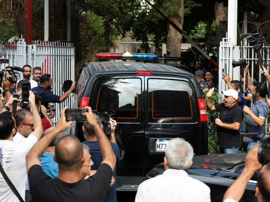 متظاهرون وإعلاميون يتجمعون بالقرب من سيارة ضمن موكب رئيس البنك المركزي اللبناني السابق رياض سلامة لدى وصولها إلى قصر العدل في بيروت، لبنان. 9 سبتمبر 2024 - Reuters