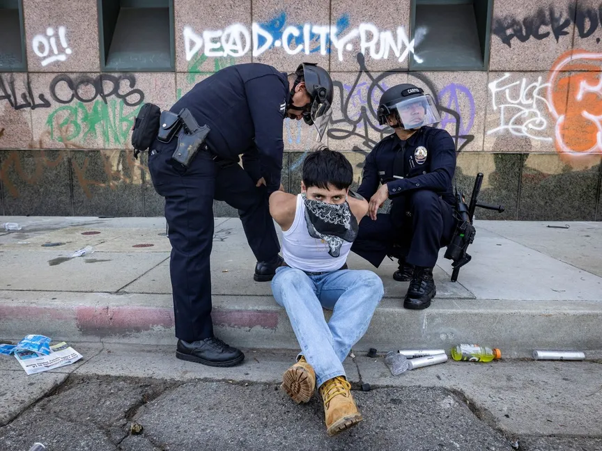 ضباط شرطة لوس أنجلوس يعتقلون متظاهراً بالقرب من مركز احتجاز في المدينة. 8 يونيو 2025 - REUTERS