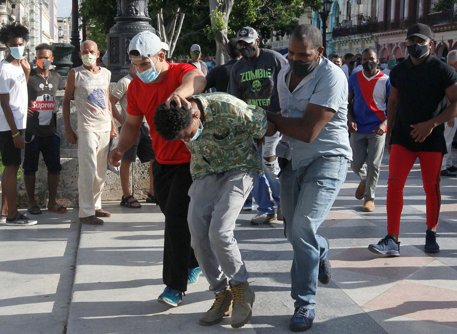 عنصران من الشرطة يرتديان ملابس مدنية يحتجزان متظاهراً ضد الحكومة في هافانا - 11 يوليو 2021 - REUTERS