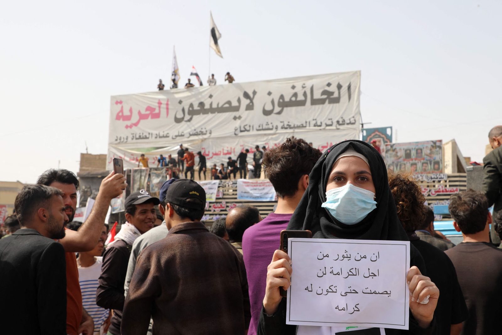 An Iraqi carries a placard which reads in Arabic