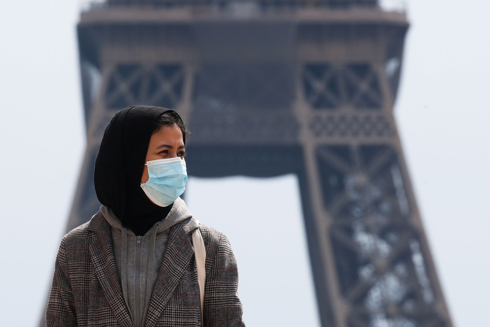 امرأة ترتدي الحجاب تمشي في ميدان تروكاديرو بالقرب من برج إيفل في باريس - REUTERS