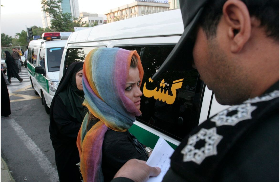 عنصر من شرطة الأخلاق الإيرانية يحرر اسم سيدة اعتقلها في أحد شوارع طهران- 18 يونيو 2008 - REUTERS