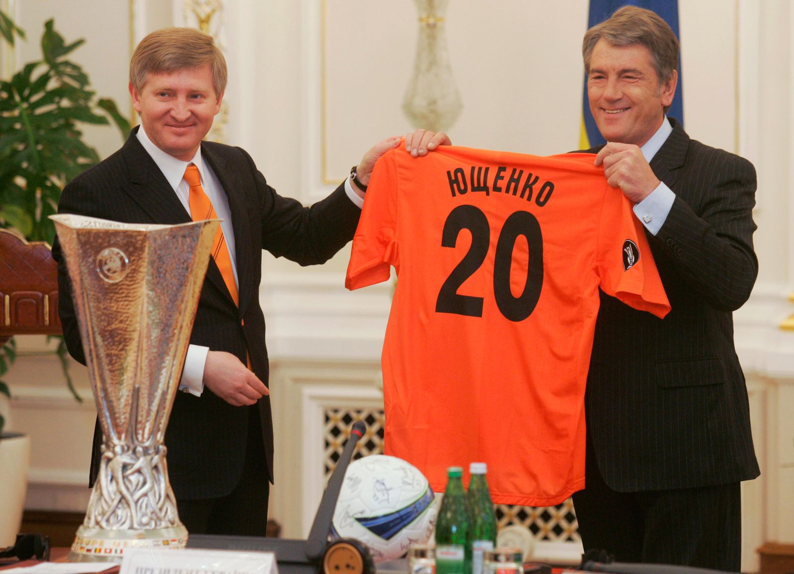 الملياردير الأوكراني رينات أحمدوف (يسار)، رئيس نادي شاختار دونيتسك لكرة القدم، يسلّم قميص الفريق إلى الرئيس الأوكراني السابق فيكتور يوتشينكو في كييف - 26 مايو 2009 - REUTERS