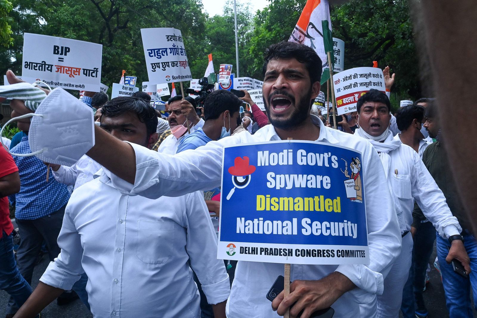 India's Congress party workers carrying banners and placards shout slogans as they take part in a demonstration against the Bharatiya Janata Party (BJP)led government and  Indian Prime Minister Narendra Modi against alleged surveillance operation using the Pegasus spyware, in New Delhi on July 20, 2021. (Photo by Prakash SINGH / AFP) - AFP