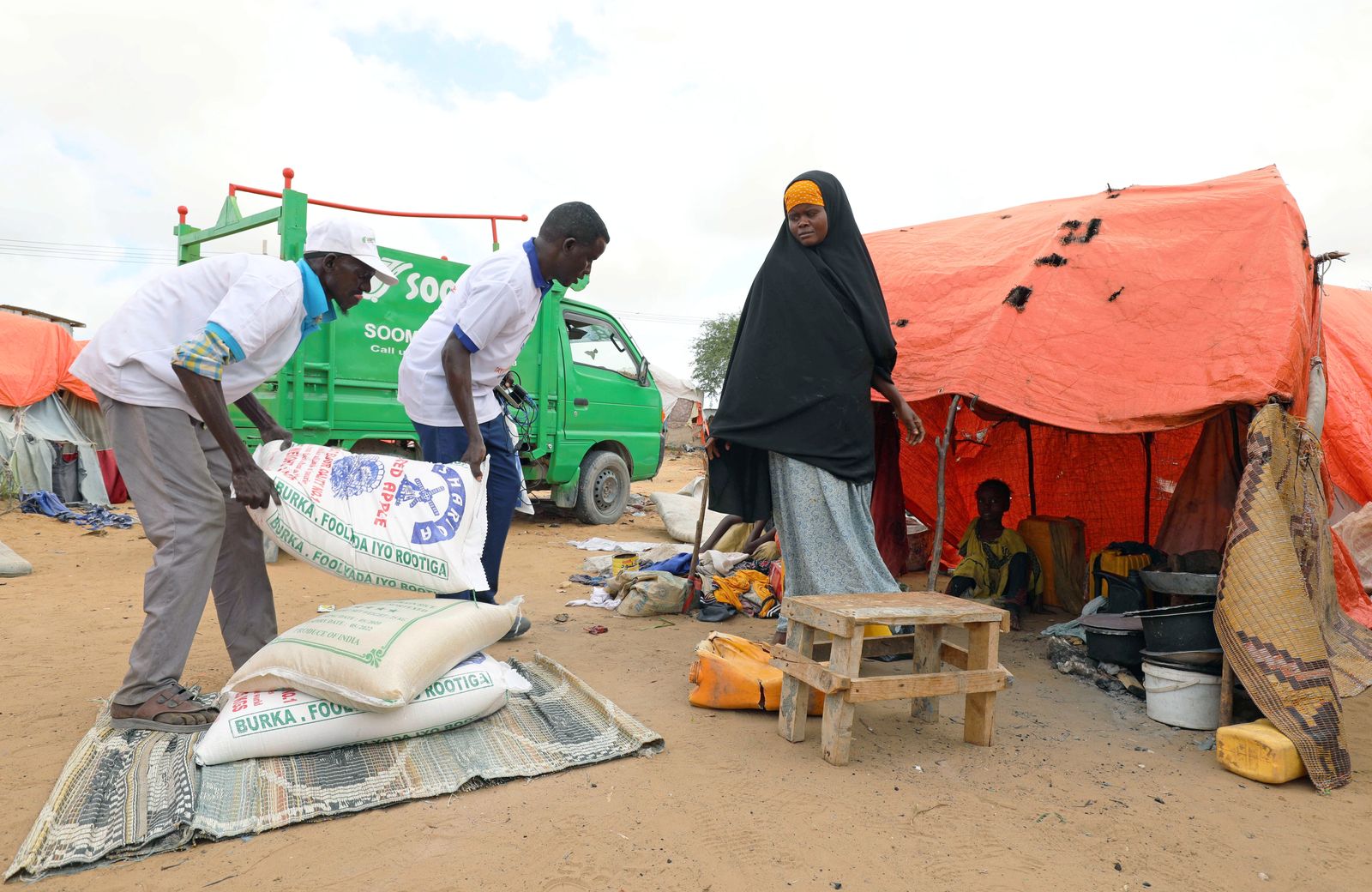 أفراد في الصومال يتسلمون بعض الأغذية والمؤن التي توزعها المنظمات الدولية. - REUTERS