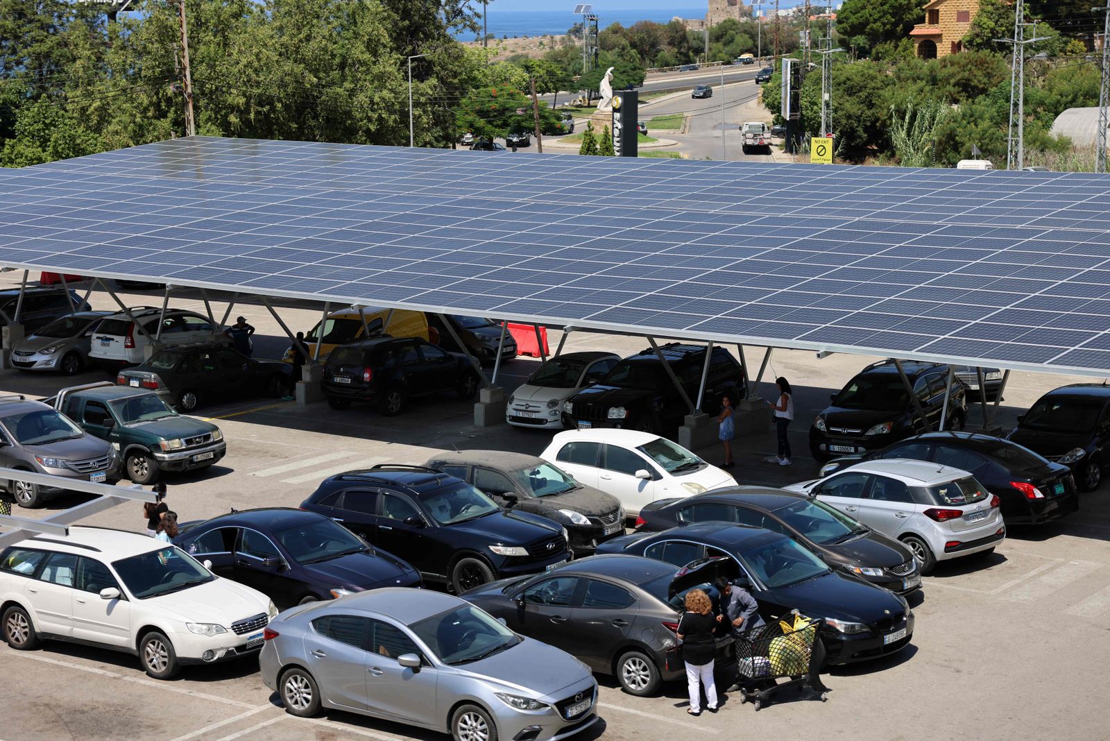Solar panels are installed as shades above vehicles in the parking garage of a shopping mall in the city of Byblos in northern Lebanon on August 26, 2022. - Lebanon's economy collapsed in 2019 after decades of corruption and mismanagement, leaving the state unable to provide electricity for more than an hour or two. Last winter, the mountain village barely had three hours of daily generator electricity. Solar power now helps keep the lights on for 17 hours, an engineer working on the project said, providing a semblance of normality. (Photo by JOSEPH EID / AFP) - AFP