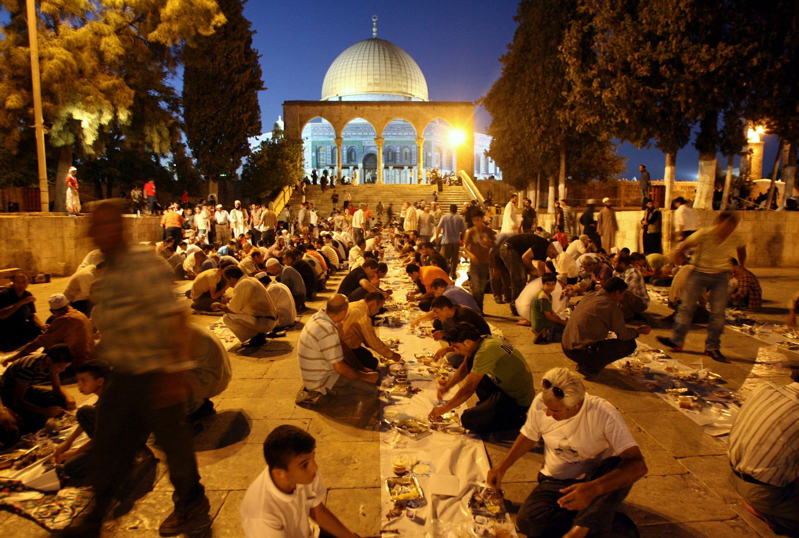عشرات الفلسطينيين يفطرون خارج قبة الصخرة الذهبية في المسجد الأقصى بالقدس في رمضان  2008. - AFP