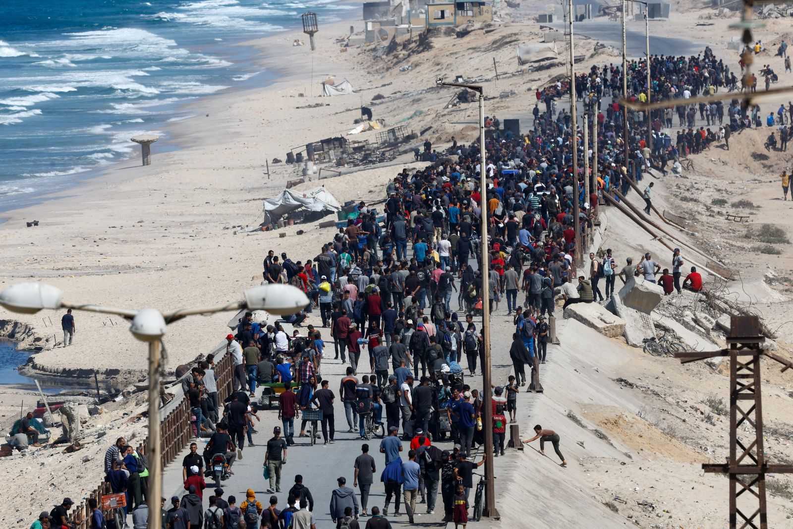 Palestinians, who were displaced to the southern part of Gaza at Israel's order during the war, walk as they attempt to return to the north after a ceasefire between Israel and Hamas in Gaza went into effect, in the central Gaza Strip, October 10, 2025. REUTERS/Mahmoud Issa
