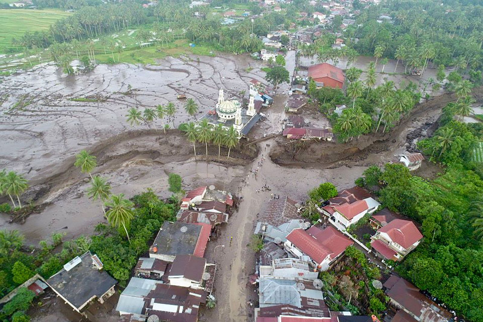 This handout aerial image taken and released by Indonesia's Disaster Mitigation Agency (BNPB) on May 12, 2024, shows the damaged area after flash floods and cold lava flow from a volcano in Tanah Datar, West Sumatra. At least 34 people have died and 16 more were missing after flash floods and cold lava flow from a volcano hit western Indonesia, a local disaster official said on May 12. (Photo by Handout / INDONESIA DISASTER MITIGATION AGENCY / AFP) / RESTRICTED TO EDITORIAL USE - MANDATORY CREDIT 'AFP PHOTO / INDONESIA DISASTER MITIGATION AGENCY' - NO MARKETING NO ADVERTISING CAMPAIGNS - DISTRIBUTED AS A SERVICE TO CLIENTS