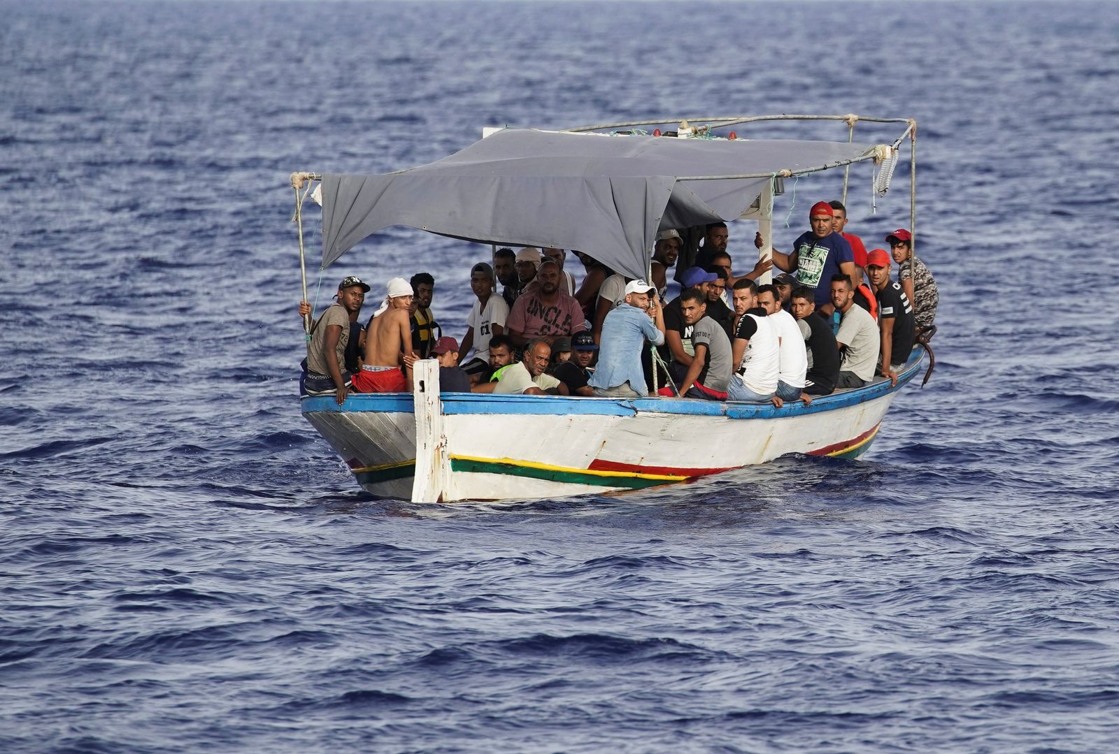 مهاجرون على متن قارب خشبي أمام جزيرة لامبيدوزا الإيطالية في البحر الأبيض المتوسط - 31 أغسطس 2021 - REUTERS