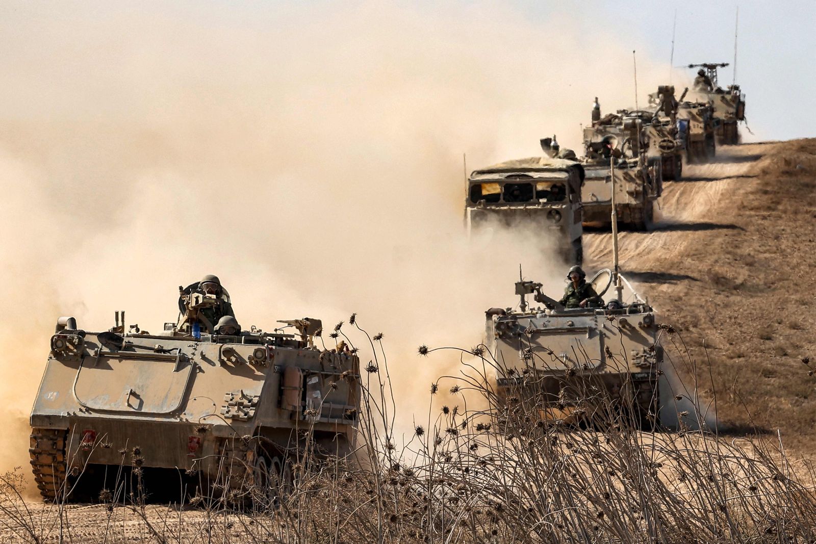 Israeli army infantry fighting vehicles (IFVs) deploy along the border with the Gaza Strip in southern Israel on October 13, 2023. Thousands of people, both Israeli and Palestinians have died since October 7, 2023, after Palestinian Hamas militants entered Israel in a surprise attack leading Israel to declare war on Hamas in the Gaza Strip enclave on October 8. (Photo by JACK GUEZ / AFP)