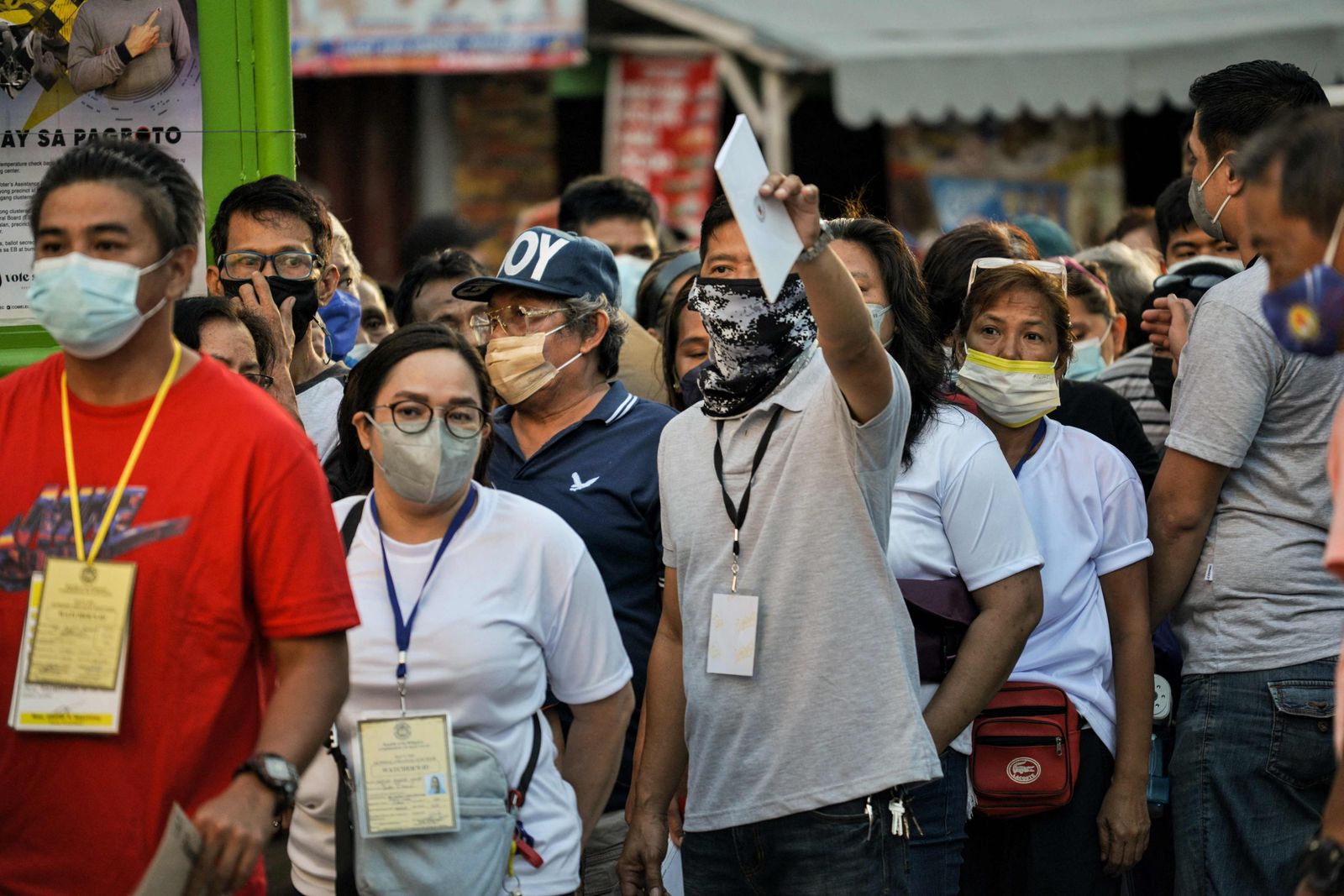 People queue before casting their votes during the presidential election�at a polling station in Manila on May 9, 2022. (Photo by CHAIDEER MAHYUDDIN / AFP) - AFP