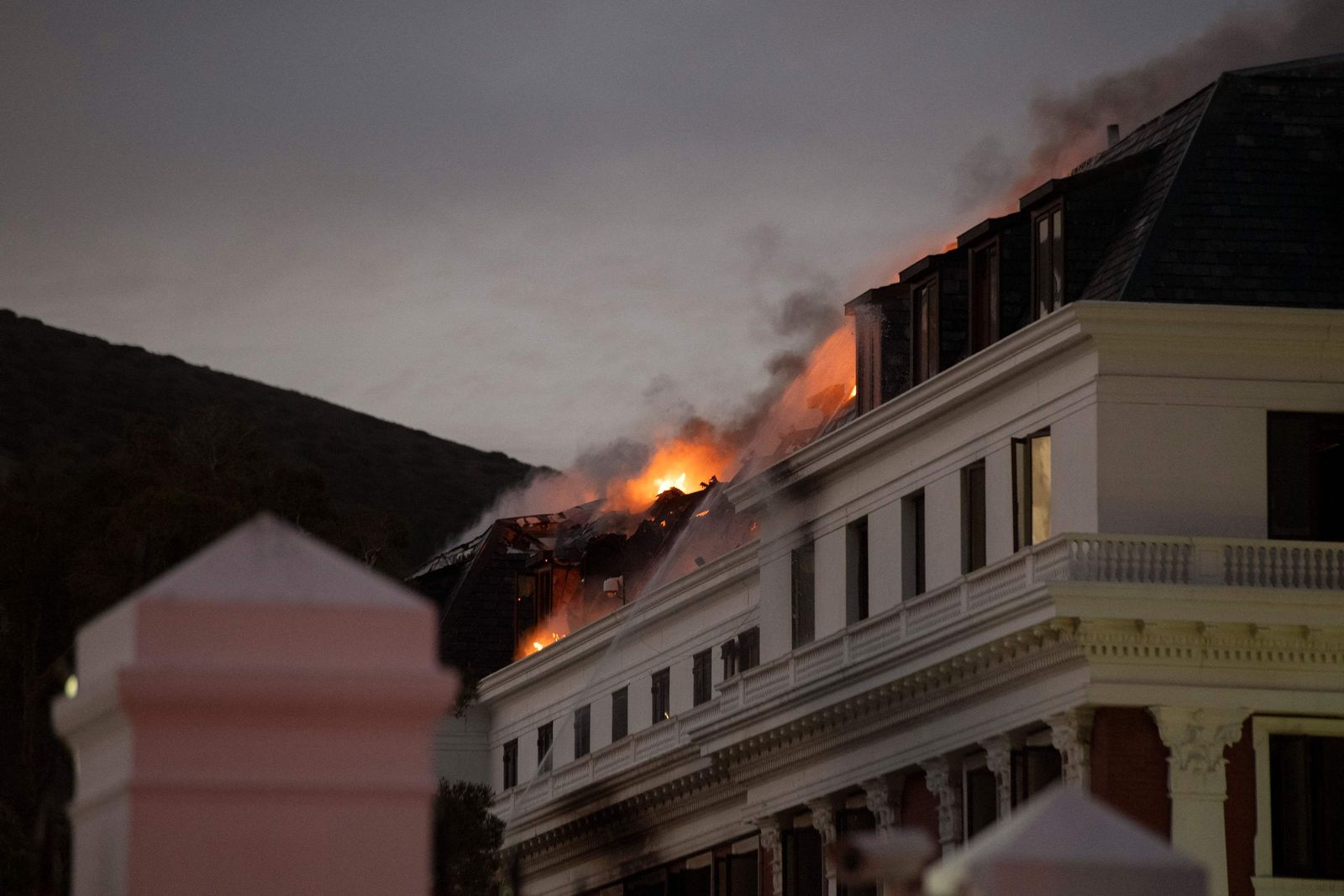 Flames arise from the National Assembly, the main chamber of the South African Parliament buildings, after a fire that broke out the day before restarted, on January 3, 2022, in Cape Town. (Photo by RODGER BOSCH / AFP) - AFP