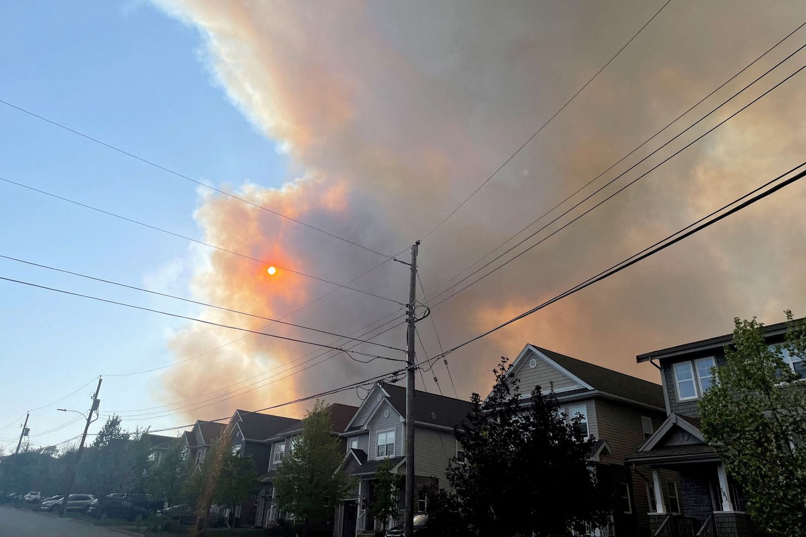 FILE PHOTO: Smoke from the Tantallon wildfire rises over houses in nearby Bedford - REUTERS