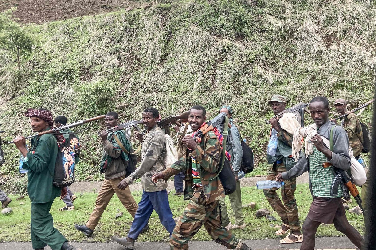 Members of the Amhara militia walk along the road in a rural area near the village of Adi Arkay, 180 kilometers northeast from the city of Gondar, Ethiopia, on July 14, 2021. - On Wednesday the Amhara government spokesman Gizachew Muluneh announced that regional special forces and militias would shift to 