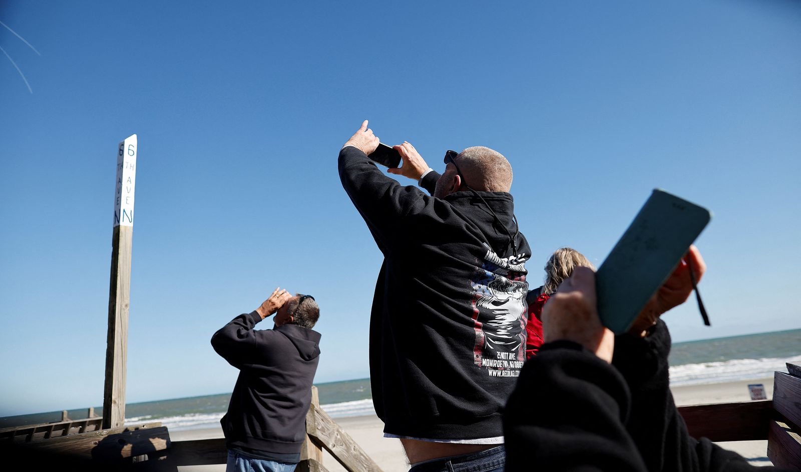 People photograph a suspected Chinese spy balloon as it floats off the coast in Surfside Beach - REUTERS