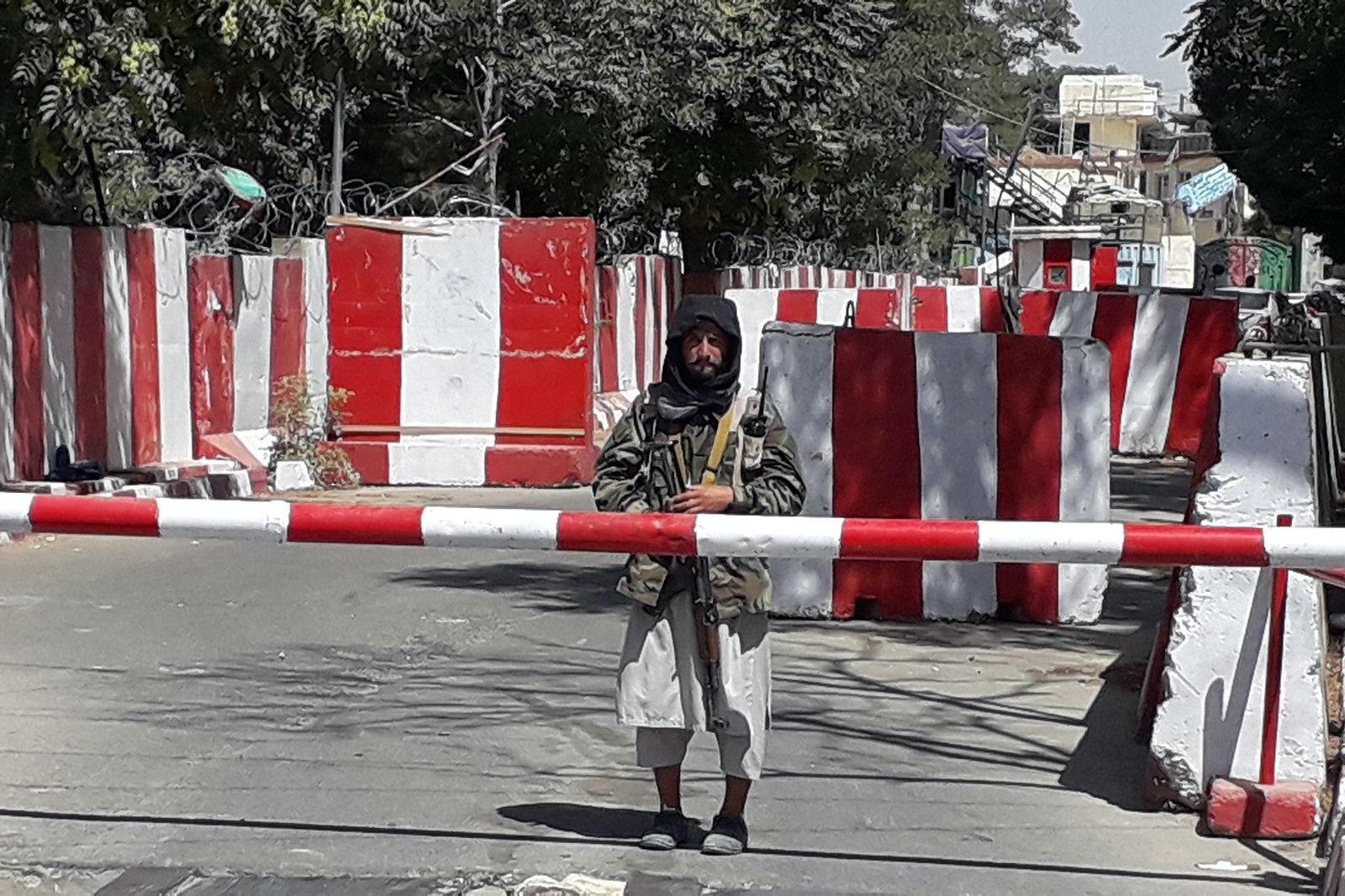مقاتل من طالبان يقف عند مدخل مقر شرطة مدينة غزنة - 12 أغسطس 2021 - AFP