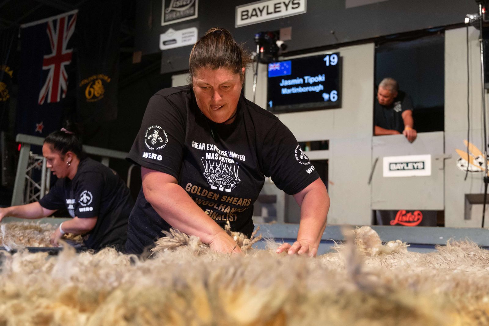 A picture taken on March 4, 2023 shows Keryn Herbert of the Cook Islands sorting a fleece as she competes in the wool handlers section during the Golden Shears International sheep shearing competition at The Wool Shed in Masterton. (Photo by Marty MELVILLE / AFP) - AFP