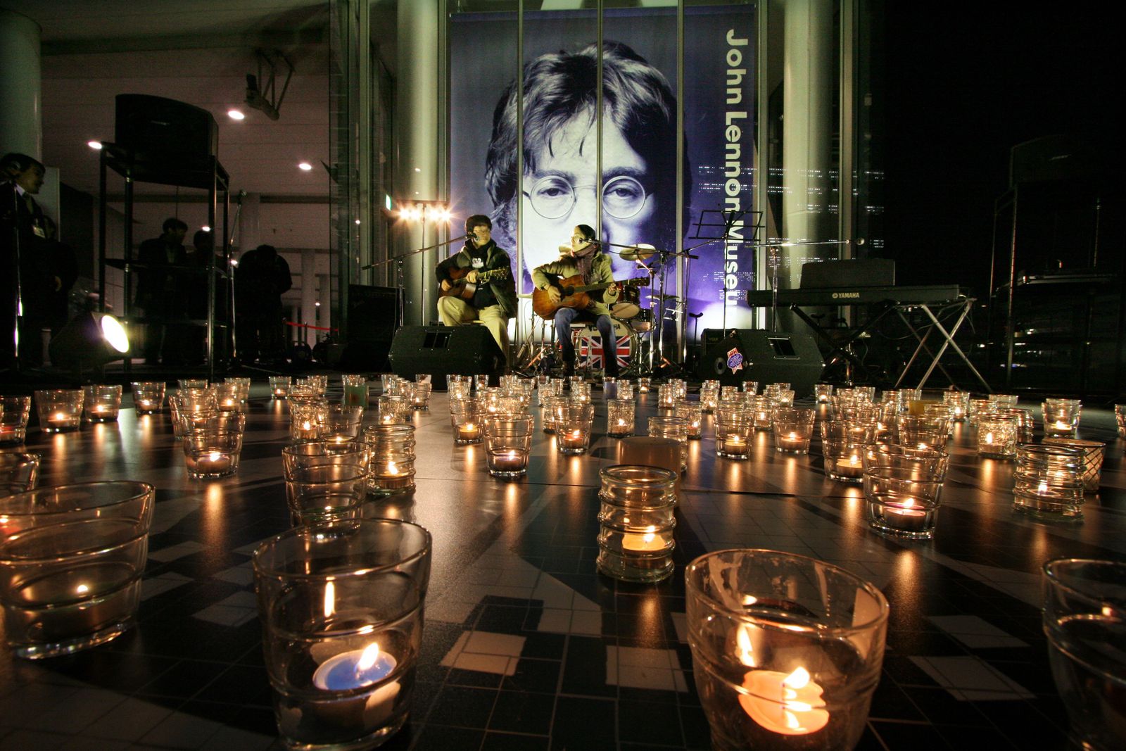 موسيقيون هواة يابانيون يؤدون عرضاً أمام صورة جون لينون، الذي قُتل في نيويورك عام 1980، سايتاما شمال طوكيو، 8 ديسمبر 2005  - REUTERS
