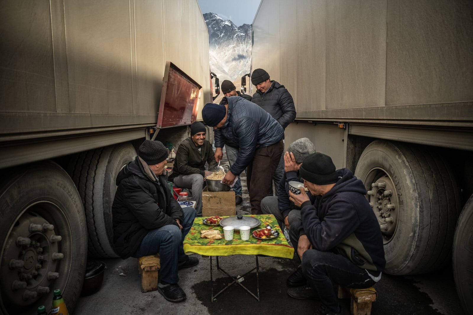 سائقو شاحنات في استراحة، بينما ينتظرون عبور الحدود من جوريا إلى روسيا - نيويورك تايمز