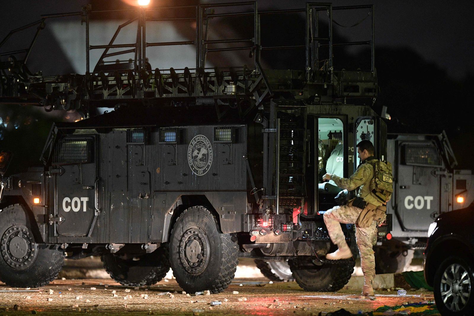 A member of Brazil's Special Operations Command (COT) gets into an armoured vehicle outside the Supreme Court after supporters of Brazilian former President Jair Bolsonaro who invaded the building were subdued, in Brasilia on January 8, 2023. - Hundreds of supporters of Brazil's far-right ex-president Jair Bolsonaro broke through police barricades and stormed into Congress, the presidential palace and the Supreme Court Sunday, in a dramatic protest against President Luiz Inacio Lula da Silva's inauguration last week. (Photo by Carl DE SOUZA / AFP) - AFP