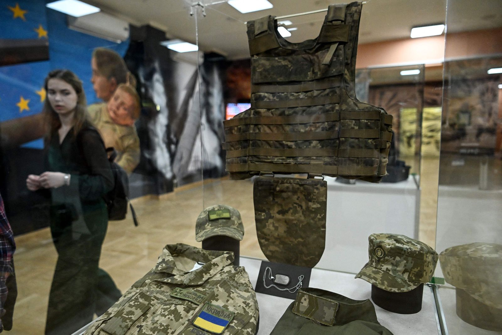 A woman looks at Ukrainian soldiers gear on display at the exhibition 